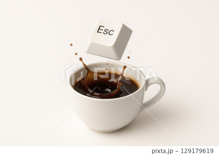 Esc button falling into a cup of coffee with a splash on a white background. Space for text. 129179619