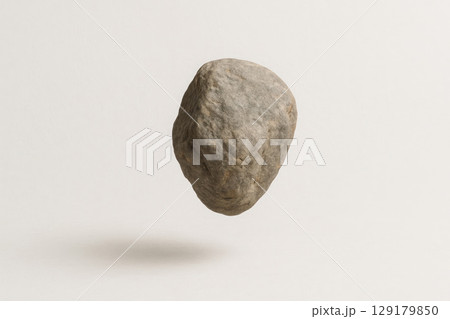 A stone floating in the air on a light background. Space for text. 129179850