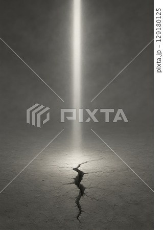 A light beam breaks through a crack in the dark floor. 129180125