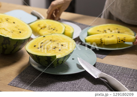 Close up shot of the cut watermelon with yellow flesh on ceramic plate 129180209