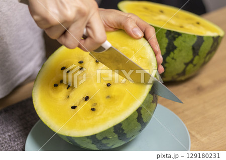 Close up shot of the cut watermelon with yellow flesh on ceramic plate. 129180231