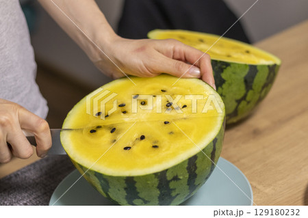 Close up shot of the cut watermelon with yellow flesh on ceramic plate. 129180232