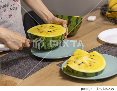Close up shot of the cut watermelon with yellow flesh on ceramic plate. 129180239