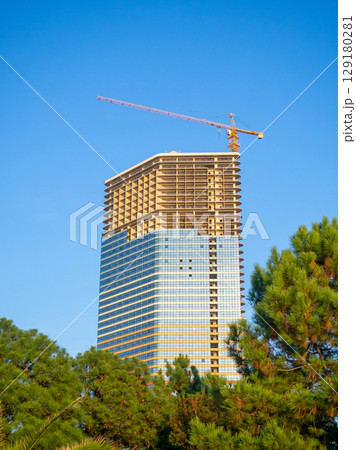 Skyscraper glazing. Finishing work. Modern building. Park and new buildings. Skyscraper glazing. Finishing work. Modern building. Park and new buildings. 129180281
