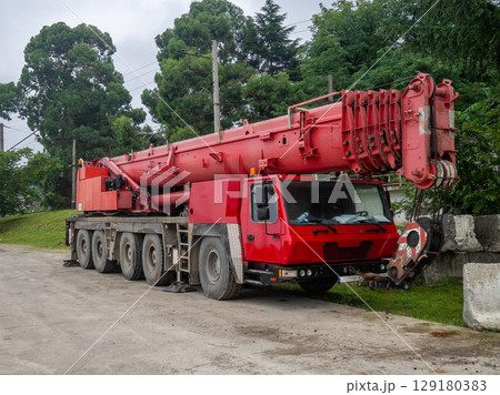 Heavy construction equipment in the parking lot. mobile crane. Red faucet. Out of work. 129180383