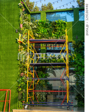 Facade of the building in green matter. Preparations for decorative work. Building reconstruction. Beautiful facade. Facade of the building in green matter. Preparations for decorative work. Building reconstruction. Beautiful facade. 129180440