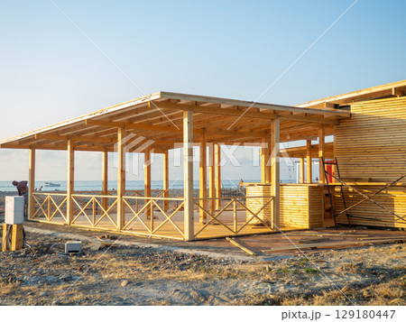 Newly built commercial building on the seafront made of wood. New restaurant. Wood restaurant. Ecology. Board building. Newly built commercial building on the seafront made of wood. New restaurant. Wood restaurant. Ecology. Board building. 129180447