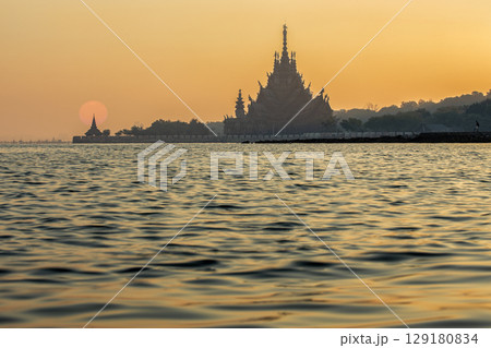 Sanctuary of Truth temple construction on sunrise in Pattaya, Thailand. The sanctuary is an all-wood building filled with sculptures based on traditional Buddhist and Hindu motifs. 129180834