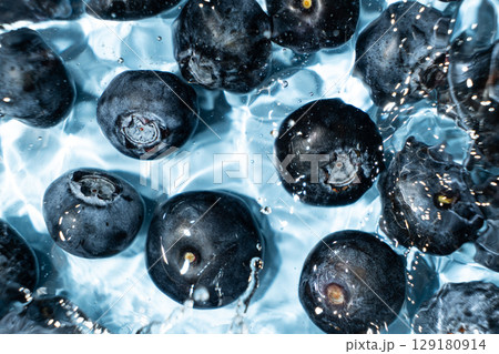Berry background of fresh whole blueberries in water, splash of water, top view Berry background of fresh whole blueberries in water, splash of water, top view 129180914