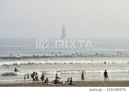 沖に停泊する大型帆船とサーファー達 沖に停泊する大型帆船とサーファー達 129180978