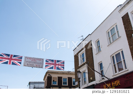 歴史的なレンガ造りの建物の間に吊り下げられたユニオンジャックの旗　ロンドンのポートベローにて 129181021