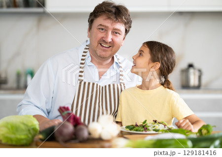 Father and daughter with cooked food in kitchen Father and daughter with cooked food in kitchen 129181416