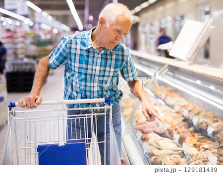 elderly retired senor asking seller for prepared food in cooking department of supermarket elderly retired senor asking seller for prepared food in cooking department of supermarket 129181439