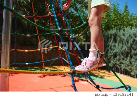 Child Balancing on Ropes at Playground with Sunny Day Outdoor Environment Child Balancing on Ropes at Playground with Sunny Day Outdoor Environment 129182141