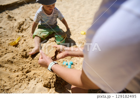 Child Playing in Sandbox With Parent on a Sunny Day Child Playing in Sandbox With Parent on a Sunny Day 129182495