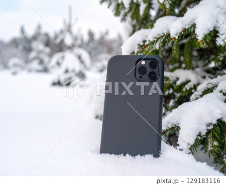 雪のクリスマスツリーとスマホケースモックアップ 雪のクリスマスツリーとスマホケースモックアップ 129183116