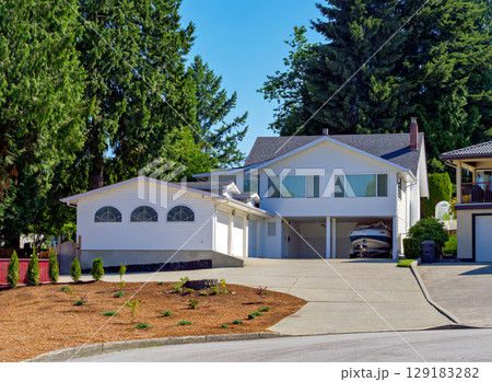 Suburban family house with small boat on trailer parked under carport Suburban family house with small boat on trailer parked under carport 129183282
