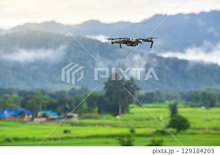 Drone copter flying with digital camera in mountains. 129184203