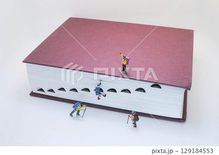 Miniature Climbers Scaling a Giant Book in Creative Concept Art 129184553