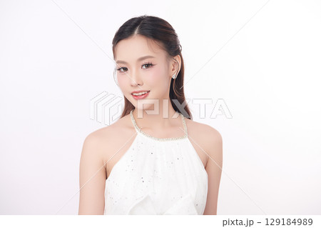 A beautiful young Asian woman with clean, fresh skin against a white background. Skincare, facial treatment, cosmetology, beauty, and spa. An elegant portrait of an Asian woman. A beautiful young Asian woman with clean, fresh skin against a white background. Skincare, facial treatment, cosmetology, beauty, and spa. An elegant portrait of an Asian woman. 129184989
