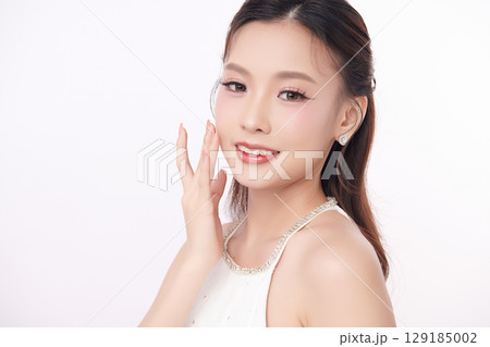 A beautiful young Asian woman with clean, fresh skin against a white background. Skincare, facial treatment, cosmetology, beauty, and spa. An elegant portrait of an Asian woman. A beautiful young Asian woman with clean, fresh skin against a white background. Skincare, facial treatment, cosmetology, beauty, and spa. An elegant portrait of an Asian woman. 129185002
