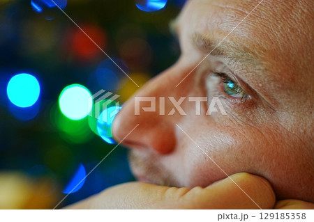 Reflective Gaze Amid Colorful Lights Reflective Gaze Amid Colorful Lights 129185358