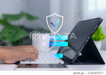 Person logging into secure system on digital tablet with shield and checkmark icon, representing cybersecurity, data protection, and confidential access in modern business technology. Person logging into secure system on digital tablet with shield and checkmark icon, representing cybersecurity, data protection, and confidential access in modern business technology. 129185377