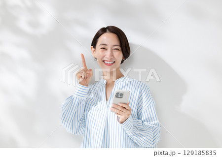 スマホを持つ女性 129185835