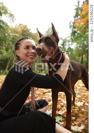 Woman spending quality time outdoors with her dog in a park setting 129186228