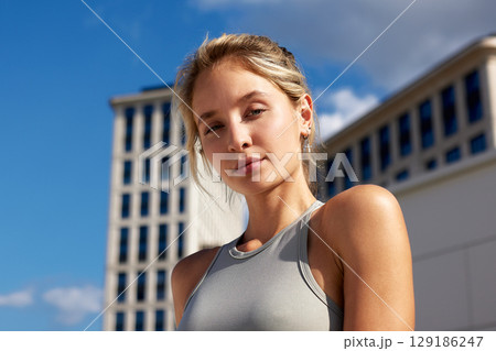Confident Woman in Urban Setting Under Clear Blue Sky 129186247