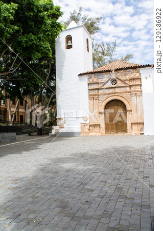 明るい日差しの中の木々に囲まれた白壁の教会 フエルテベンテュラ島のベタンクリアにて 明るい日差しの中の木々に囲まれた白壁の教会 フエルテベンテュラ島のベタンクリアにて 129186922