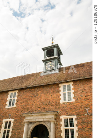 快晴の空の下の歴史的建物の赤い屋根の上に付いた時計台 ロンドン郊外のオスタリーパークにて 快晴の空の下の歴史的建物の赤い屋根の上に付いた時計台 ロンドン郊外のオスタリーパークにて 129186979
