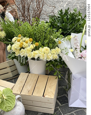 Bouquet of fresh flowers with greenery on display at outdoor market 129187064