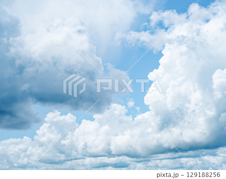 Serene light blue sky, fluffy white clouds, peaceful and dreamy atmosphere. Perfect for calming backgrounds. 129188256