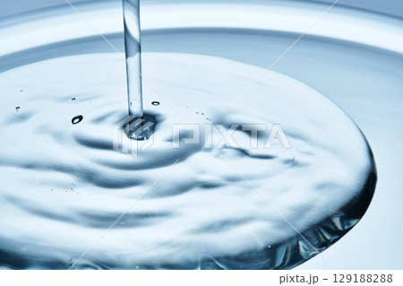 A drop of serum pouring from above with a gel or jelly texture. A drop of serum pouring from above with a gel or jelly texture. 129188288