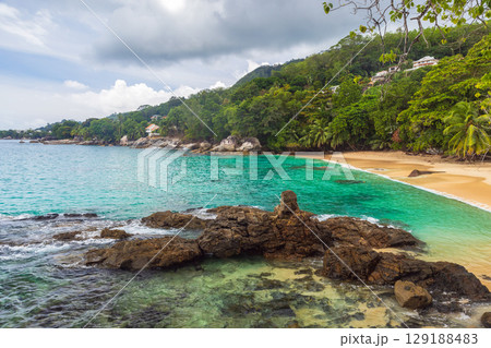 Idyllic Tropical Beach Cove With Azure Water and Lush Greenery 129188483