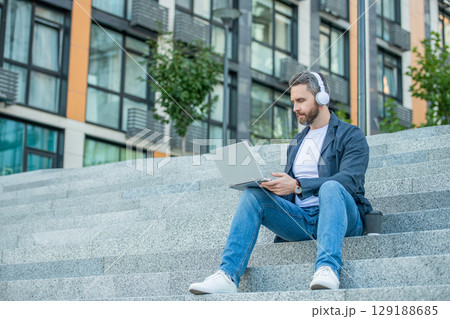 man webinar online in the street, copy space. man webinar online outside. man webinar online in the street, copy space. man webinar online outside. 129188685