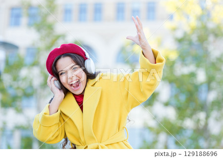 Little girl listening music enjoy favorite song. Girl with headphones urban background. Positive influence of music. Child girl french style outfit enjoying music. Childhood and teenage music taste Little girl listening music enjoy favorite song. Girl with headphones urban background. Positive influence of music. Child girl french style outfit enjoying music. Childhood and teenage music taste 129188696