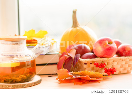 Autumn still life, warm tea, apples and books on the windowsill. Cozy autumn. 129188703