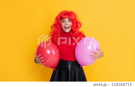 shocked teen child with party balloon on yellow background 129188713