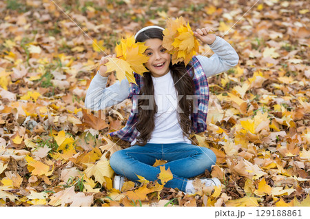 happy teenage girl listen music wearing headphones in autumn forest with beautiful seasonal nature or having online lesson, fun happy teenage girl listen music wearing headphones in autumn forest with beautiful seasonal nature or having online lesson, fun 129188861