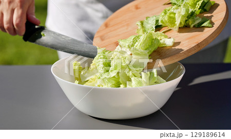 chef put in bowl sliced fresh green romaine lettuce leaves chef put in bowl sliced fresh green romaine lettuce leaves 129189614