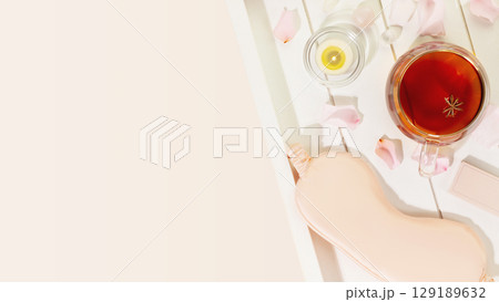 Sleep care banner with mask for sleep, cup of tea, candle and rose petals on wooden tray with copy space. Concept of relax, self care and me time. Insomnia or depression treatment for sleepless nights Sleep care banner with mask for sleep, cup of tea, candle and rose petals on wooden tray with copy space. Concept of relax, self care and me time. Insomnia or depression treatment for sleepless nights 129189632