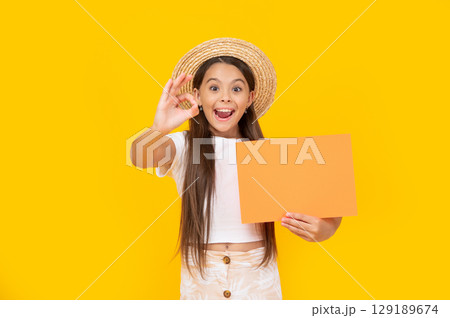amazed teen kid with copy space on orange paper on yellow background amazed teen kid with copy space on orange paper on yellow background 129189674