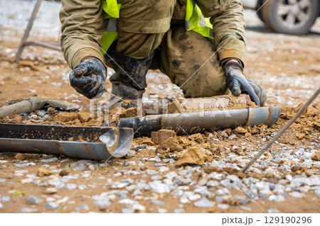 Man cutting and cleaning soil sample for laboratory analysis. Preparation of core material for geotechnical testing and scientific evaluatio Man cutting and cleaning soil sample for laboratory analysis. Preparation of core material for geotechnical testing and scientific evaluatio 129190296