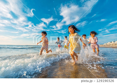 柔らかな日差しに照らされた海辺を走る子どもたちの夏風景 129190326