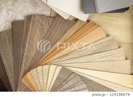 Samples of laminated chipboard. A range of gray and brown shades of wood-like boards. Concept of interior design and decor. 129190679
