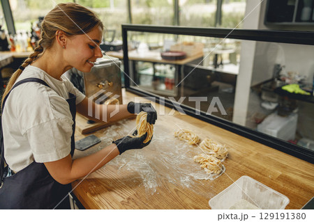 Baking Delights A Young Chef Enthusiastically at Work within a Modern Kitchen Environment Baking Delights A Young Chef Enthusiastically at Work within a Modern Kitchen Environment 129191380