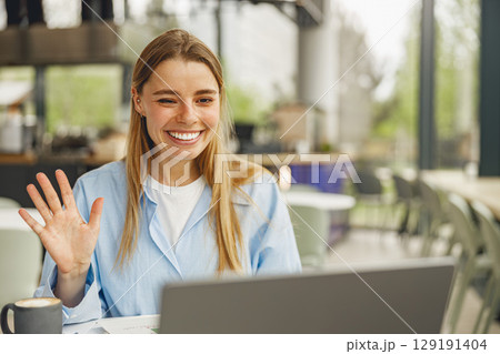 Smiling Woman Engaging in Virtual Meeting at Cozy Caf Smiling Woman Engaging in Virtual Meeting at Cozy Caf 129191404