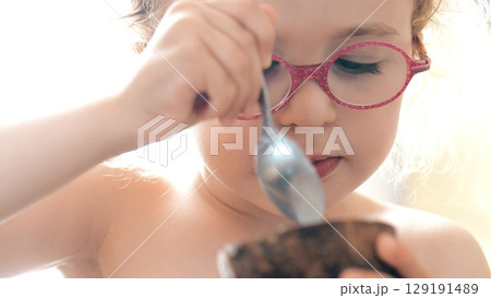Little Girl Enjoying Ice Cream from Real Coconut Shell Cup 129191489